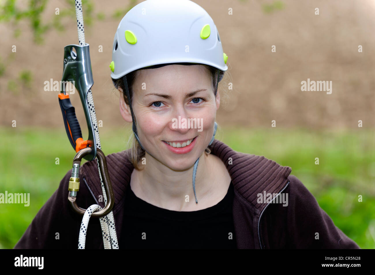Young woman with a climbing rope wearing a safety helmet Stock Photo