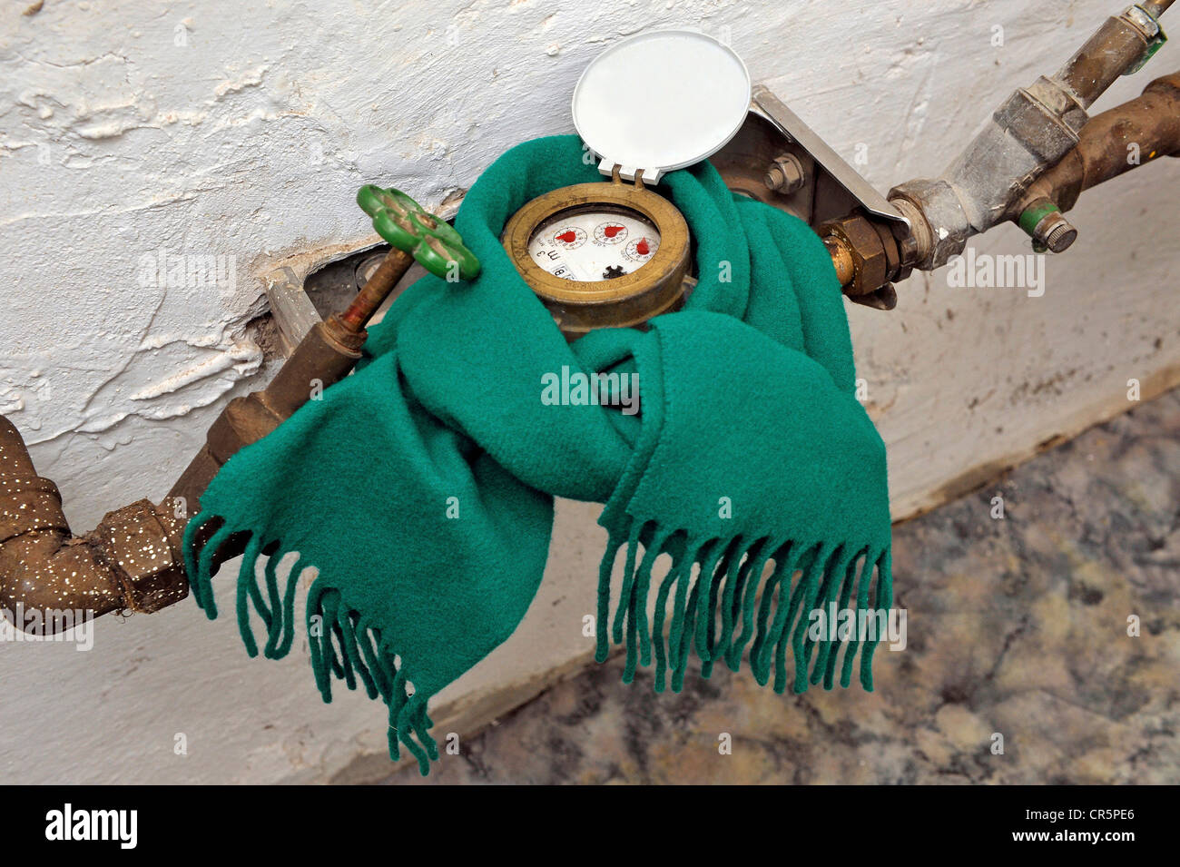Water meter with a scarf in a basement, symbolic image for protection against frost Stock Photo