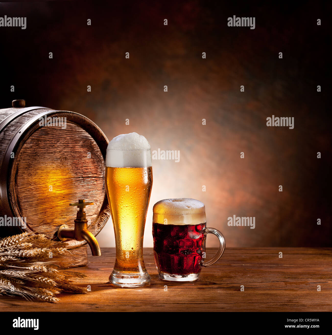Beer barrel with beer glasses on a wooden table. The dark background. Stock Photo