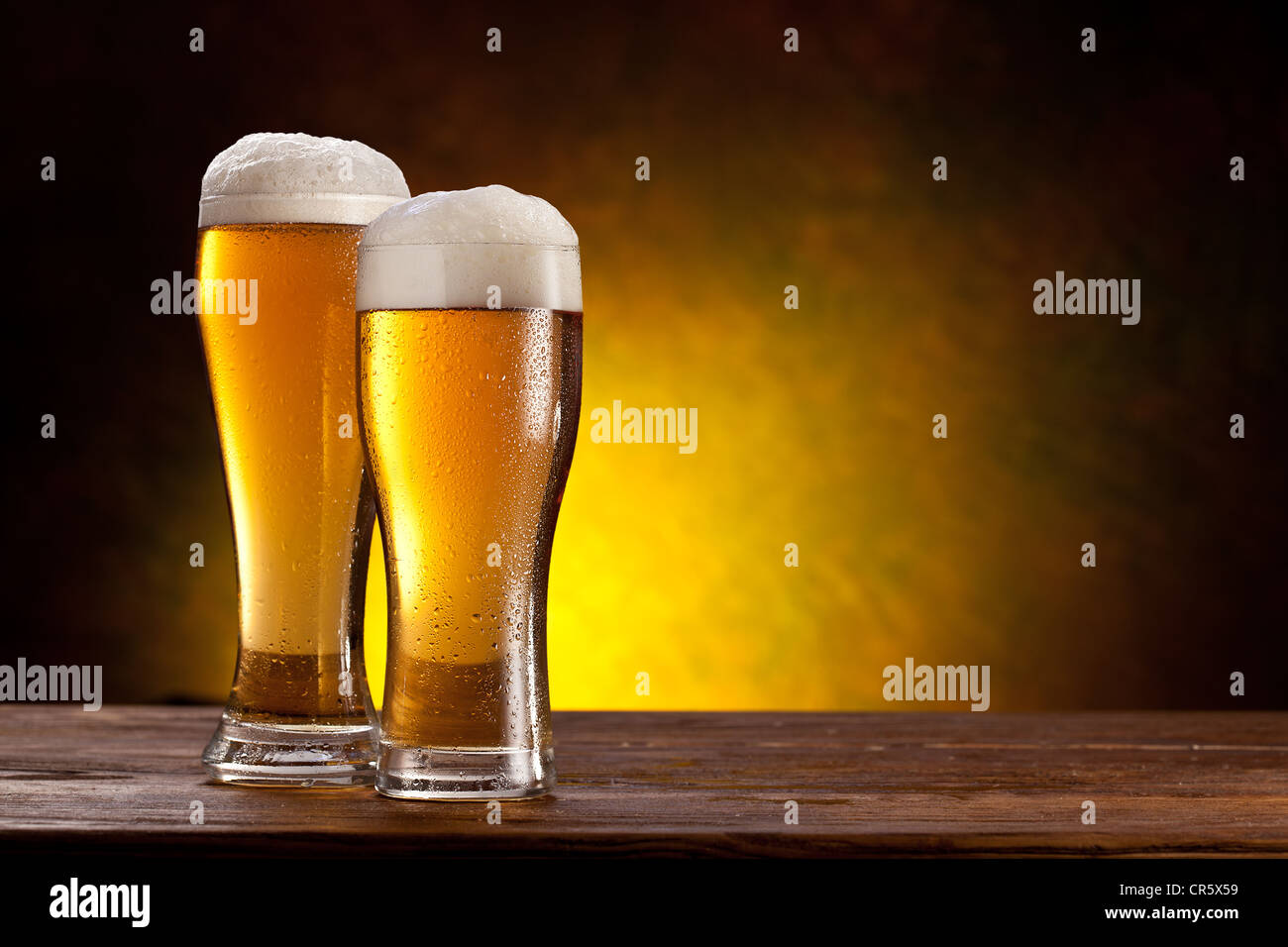 Download Two Glasses Of Beers On A Wooden Table Dark Yellow Background Stock Photo Alamy PSD Mockup Templates