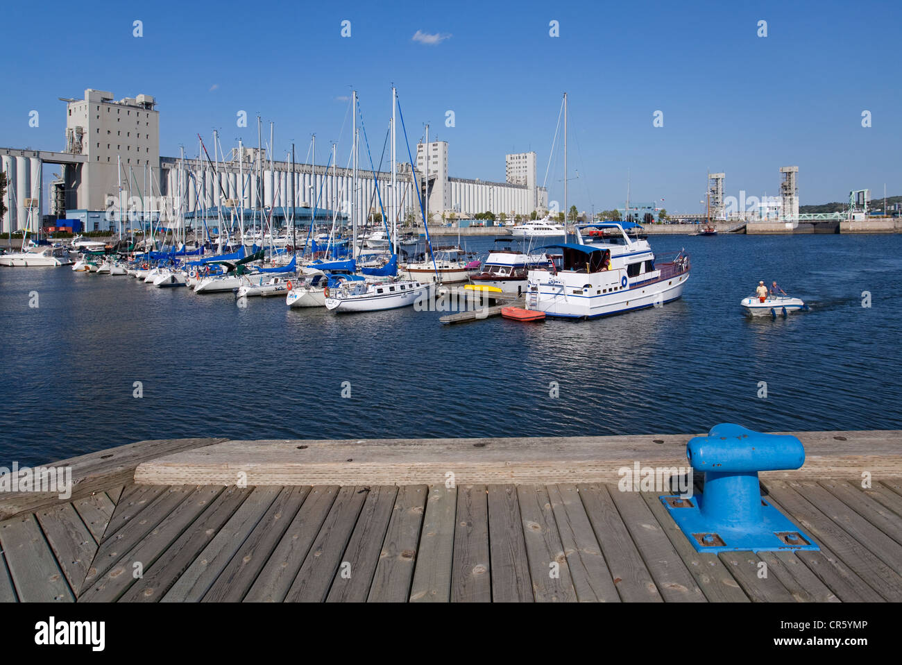 Canada, Quebec Province, Quebec City, marina with sailboats and yachts in front of the Bunge Silos, motor boat and a bitt in Stock Photo