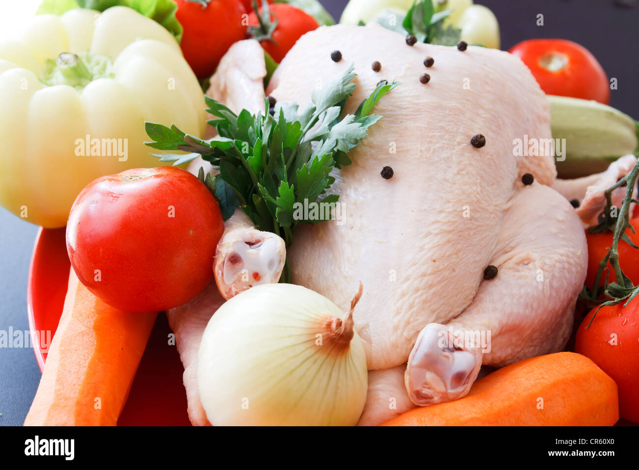 Whole raw chicken with vegetables and pepper Stock Photo