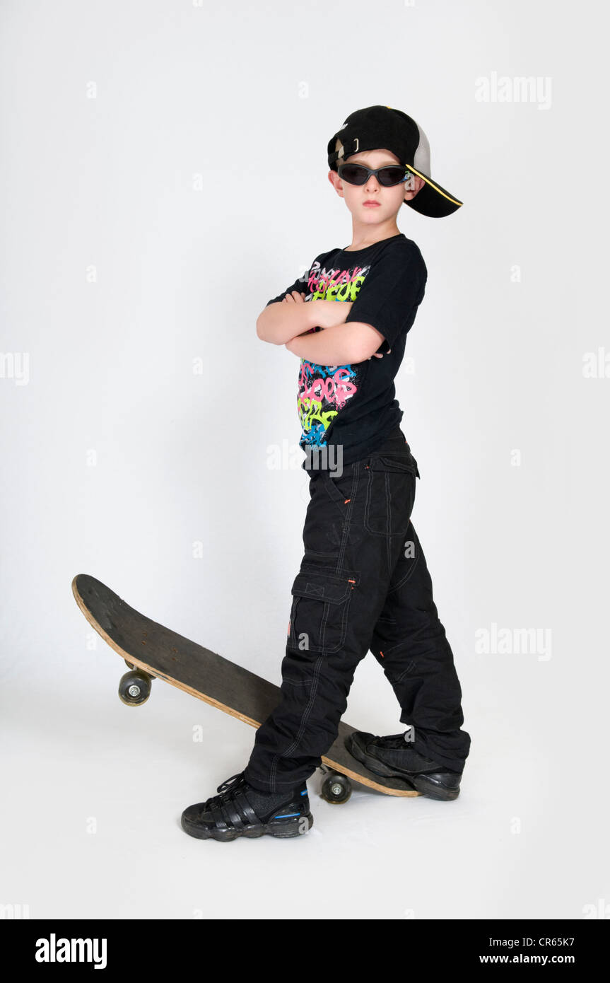 Studio image of Caucasian 8 year old boy with skateboard on a white background Stock Photo