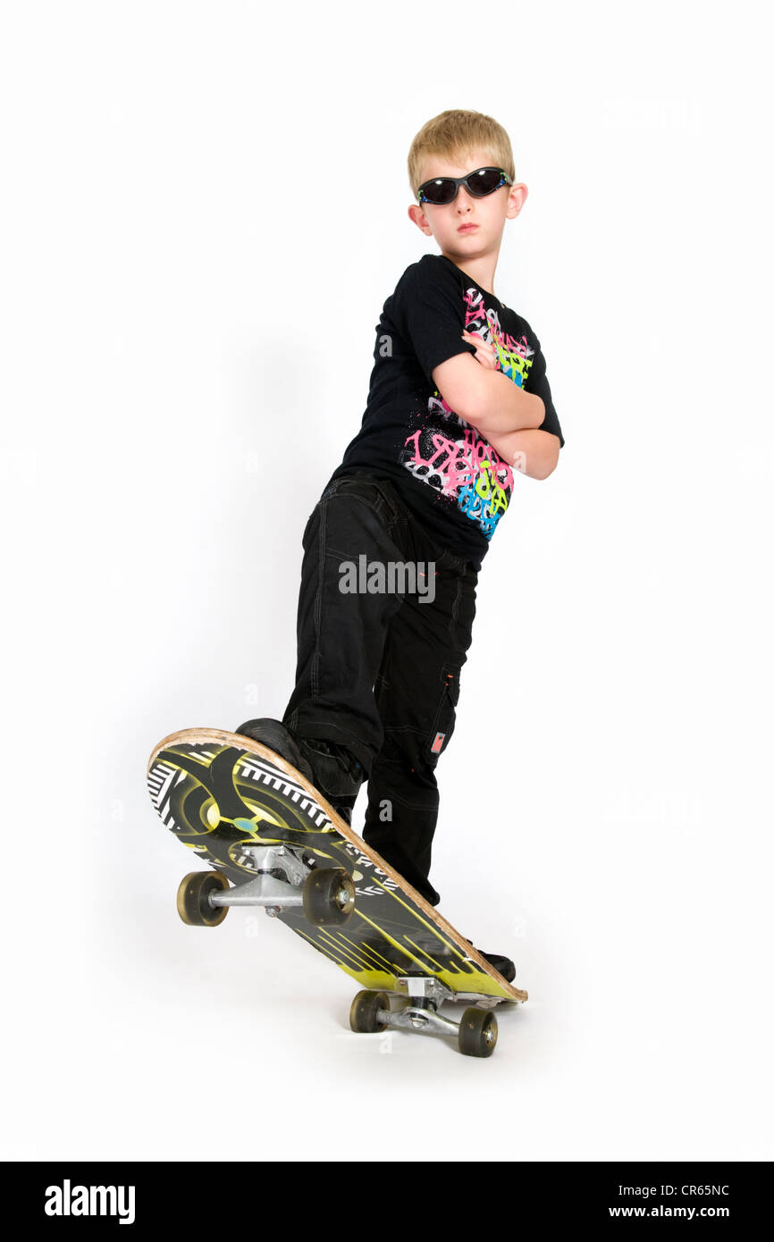 Studio image of Caucasian 8 year old boy with skateboard on a white background Stock Photo