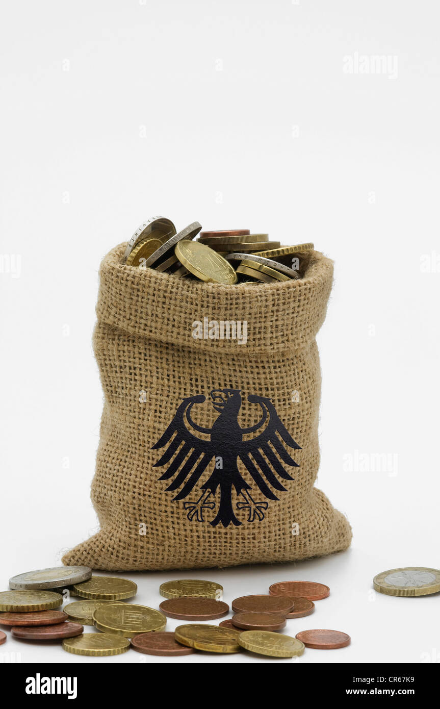 Federal eagle image on money bag filled with euro coins, coins in front of it, symbolic image for Germany's prosperity Stock Photo