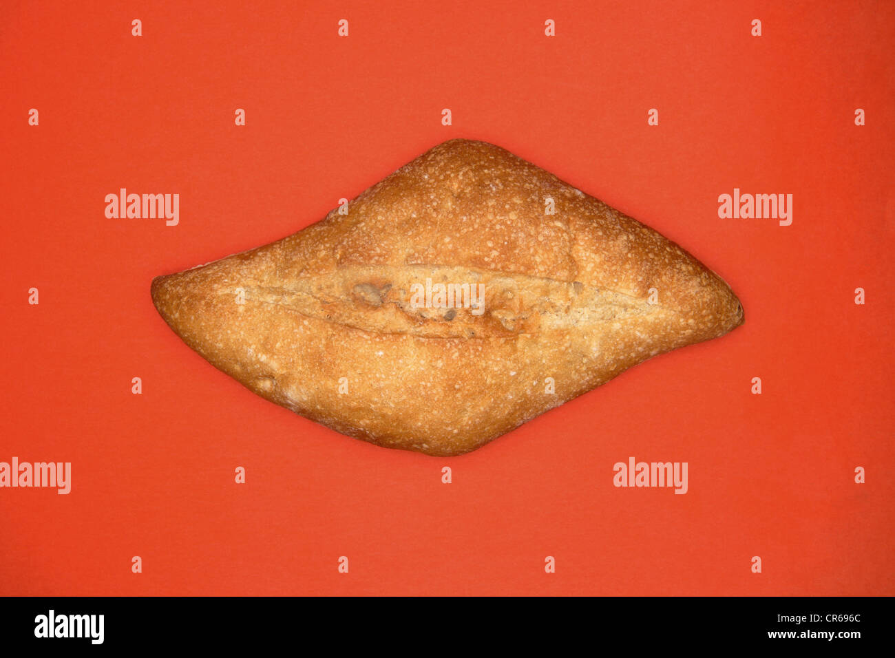 Bread bun on orange background, close up Stock Photo