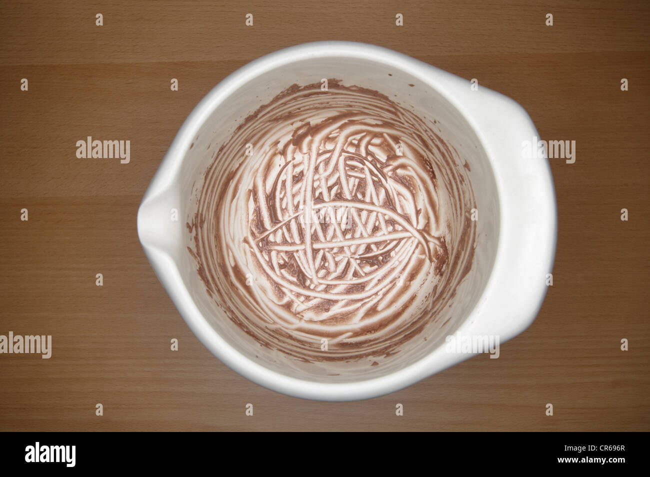 Licked out dish of chocolate pudding on wooden table, close up Stock Photo