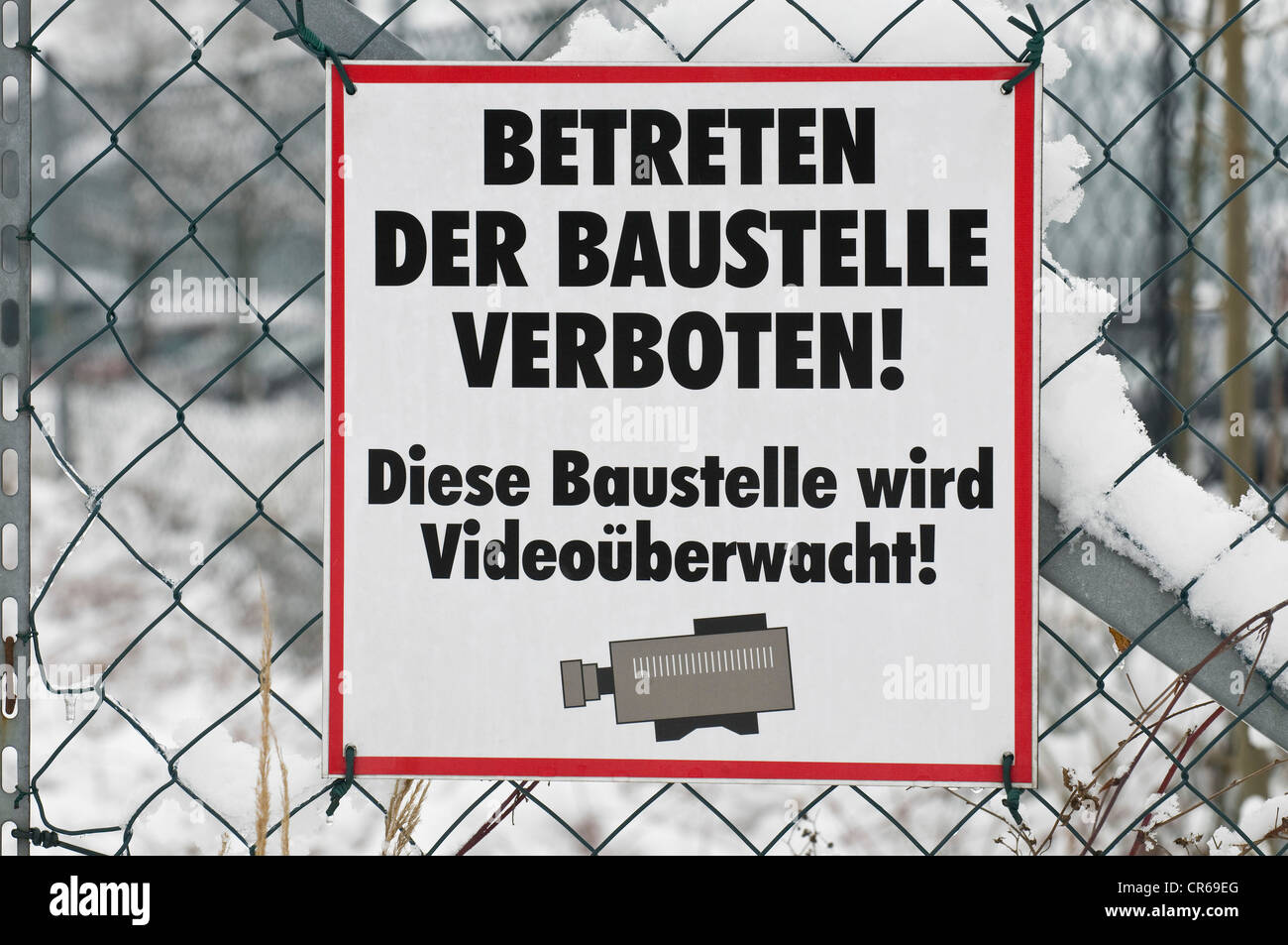 Sign on chain link fence, Betreten der Baustelle verboten Diese Baustelle wird videoueberwacht!, German for Entering the site is Stock Photo