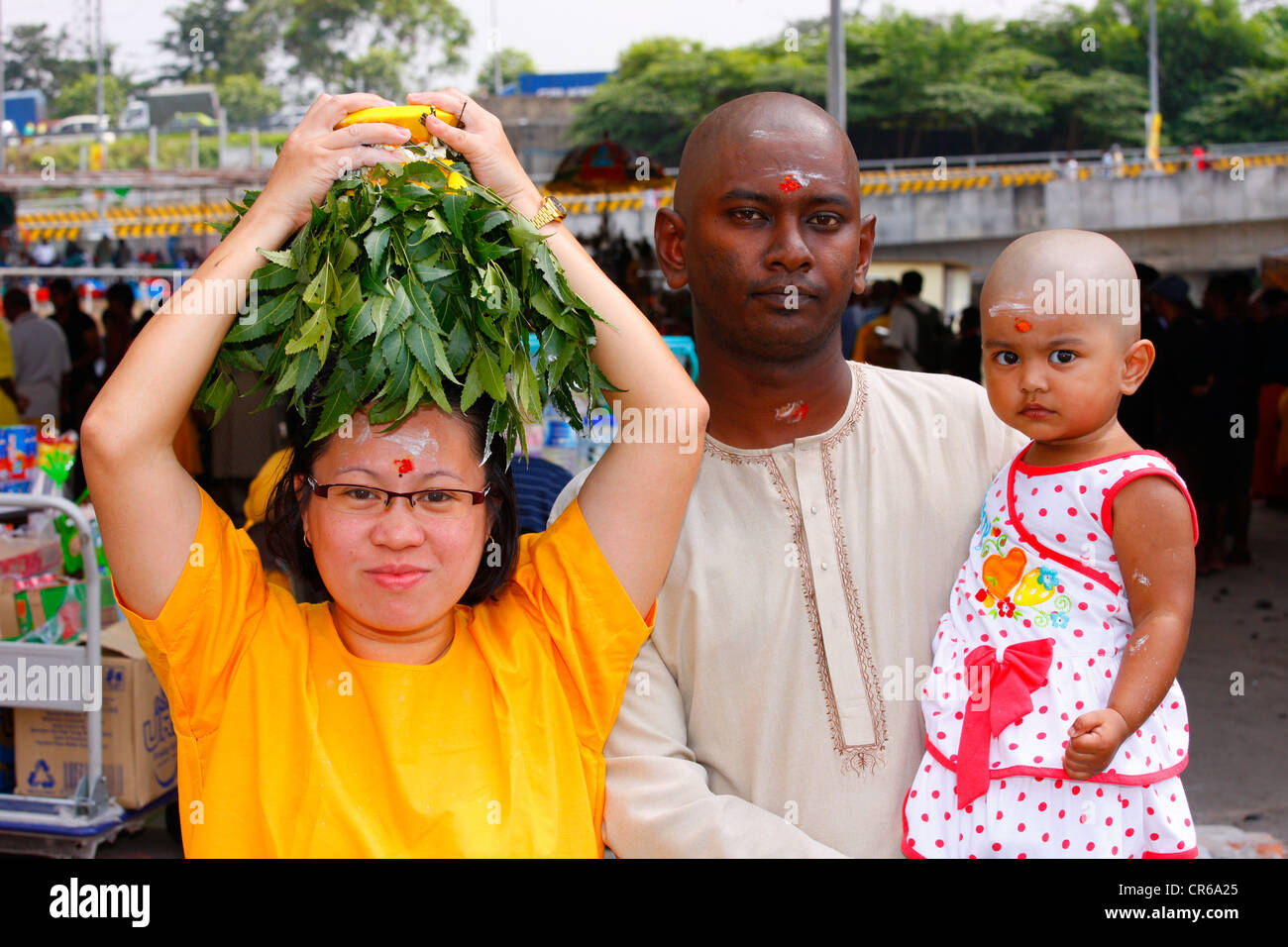 Family making a milk sacrifice, Hindu festival Thaipusam, Batu Caves limestone caves and temples, Kuala Lumpur, Malaysia Stock Photo