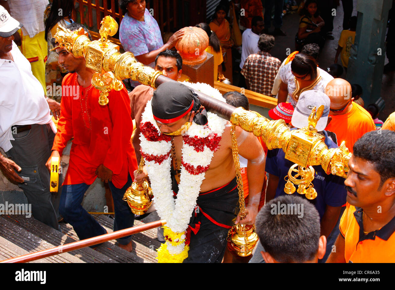 Holy man with sealed mouth and load on his shoulders, Hindu festival Thaipusam, Batu Caves limestone caves and temples Stock Photo