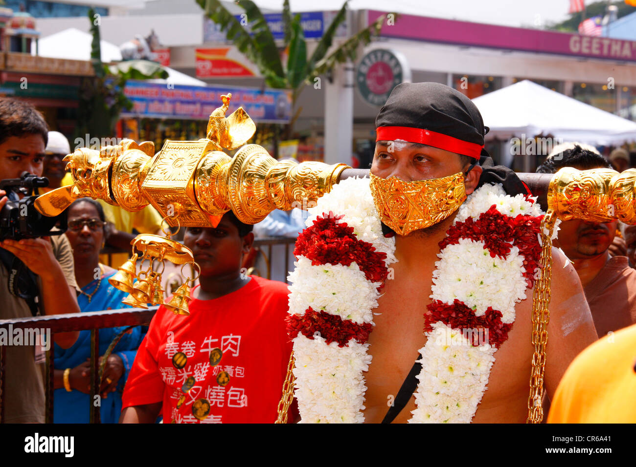 Holy man with sealed mouth and load on his shoulders, Hindu festival Thaipusam, Batu Caves limestone caves and temples Stock Photo