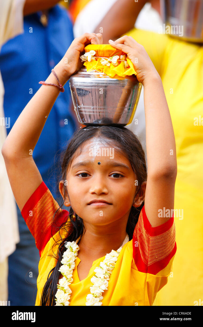 Girl making a milk sacrifice, Hindu festival Thaipusam, Batu Caves limestone caves and temples, Kuala Lumpur, Malaysia Stock Photo