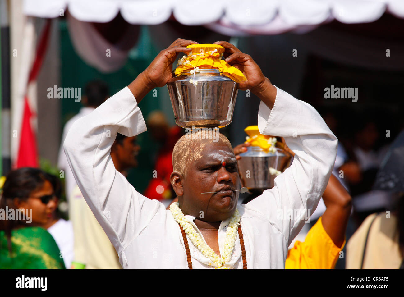 Pilgrim making a milk sacrifice, Hindu festival Thaipusam, Batu Caves limestone caves and temples, Kuala Lumpur, Malaysia Stock Photo