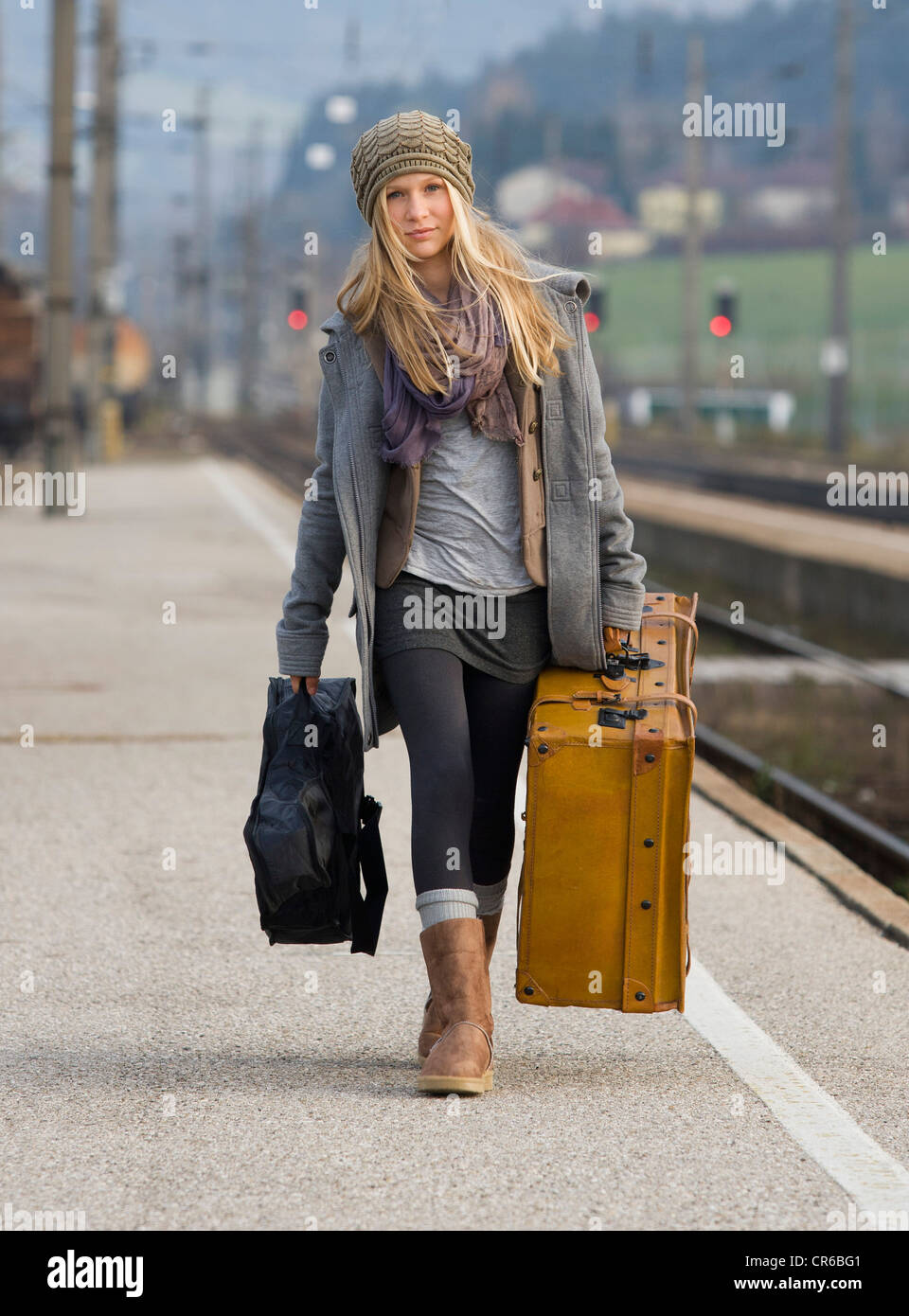 Austria, Teenage girl with suitcase on train station Stock Photo