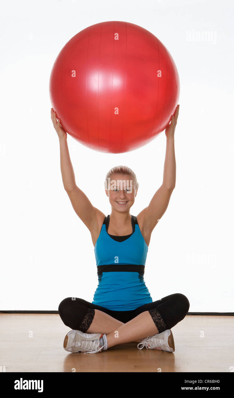 Europe, Austria, Teenage girl exercising with stability ball, portrait Stock Photo