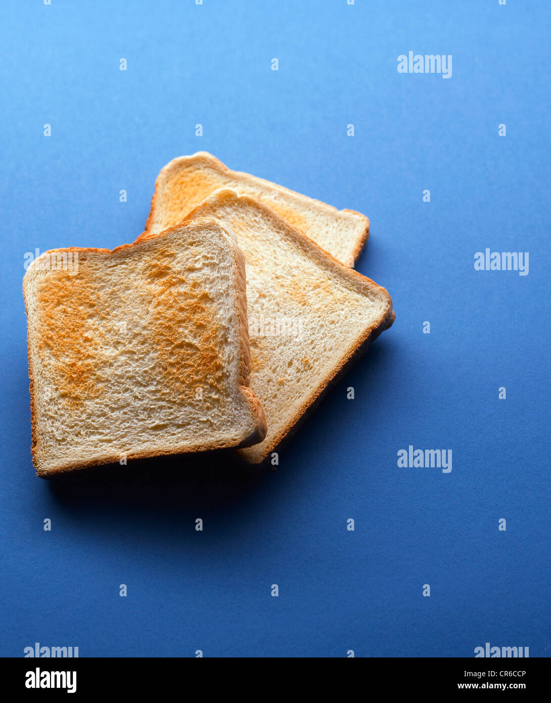Toasted bread slices on blue background Stock Photo Alamy