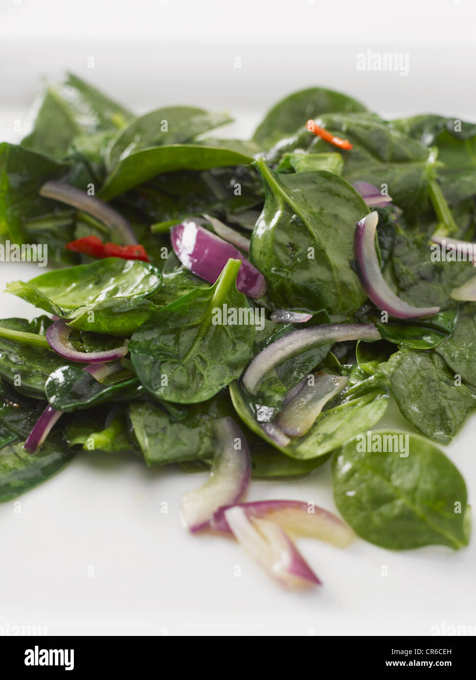 Spinach with red onion and olive oil, close up Stock Photo
