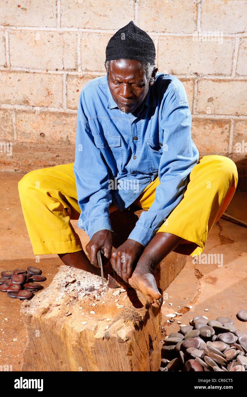Man producing traditional foot and hand rattles, Juju Rattles from Uyot ...