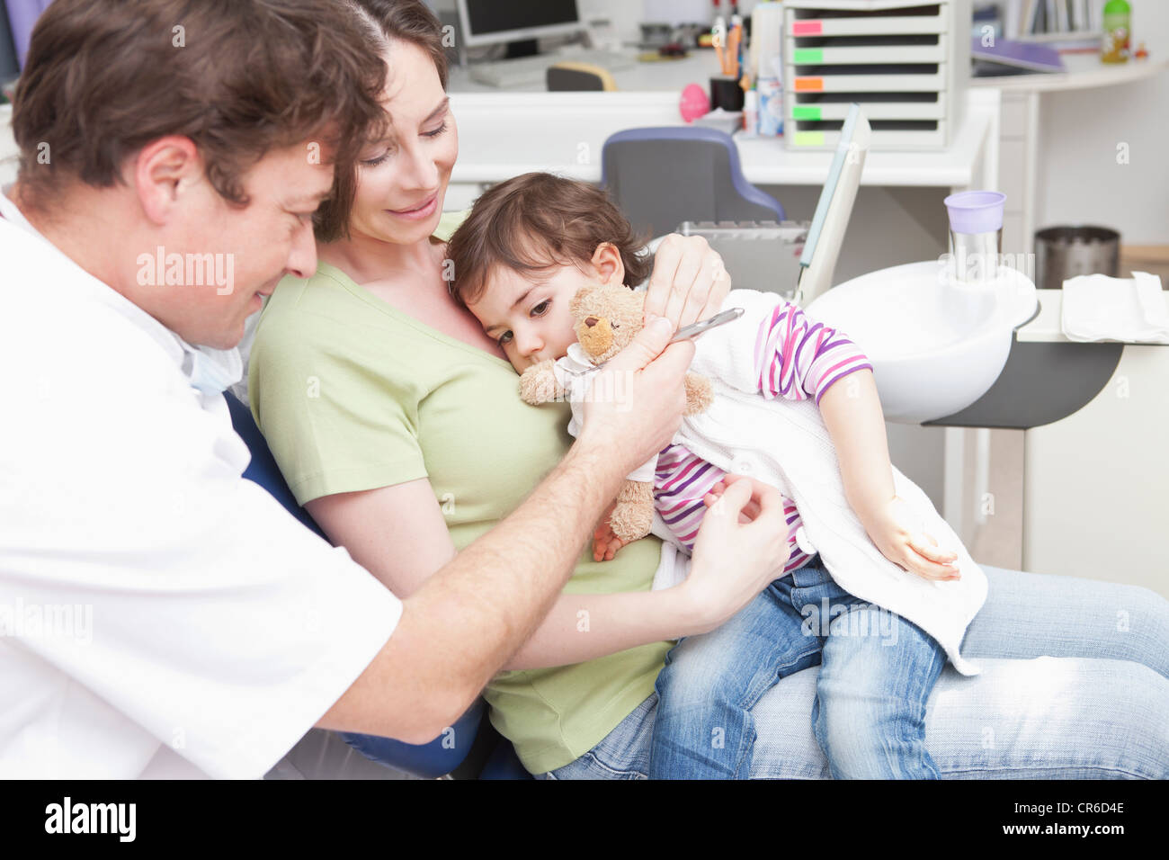 Germany, Bavaria, Dentist with woman and baby girl at clinic Stock