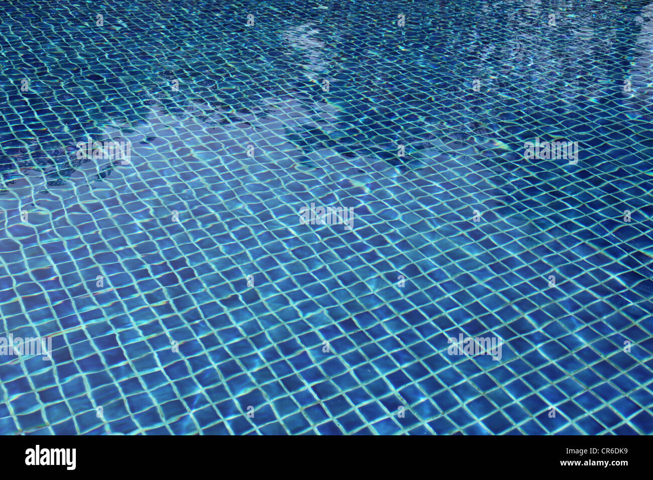 It's a photo of the water of a swimming pool with the blue tiles at the bottom of the pool. It's sunny and fresh visuals. day Stock Photo