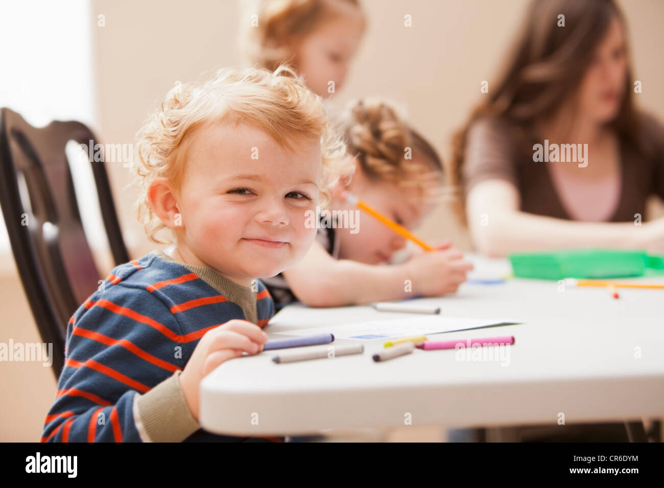 Boy (4-5) looking at camera during art lesson in kindergarten Stock ...