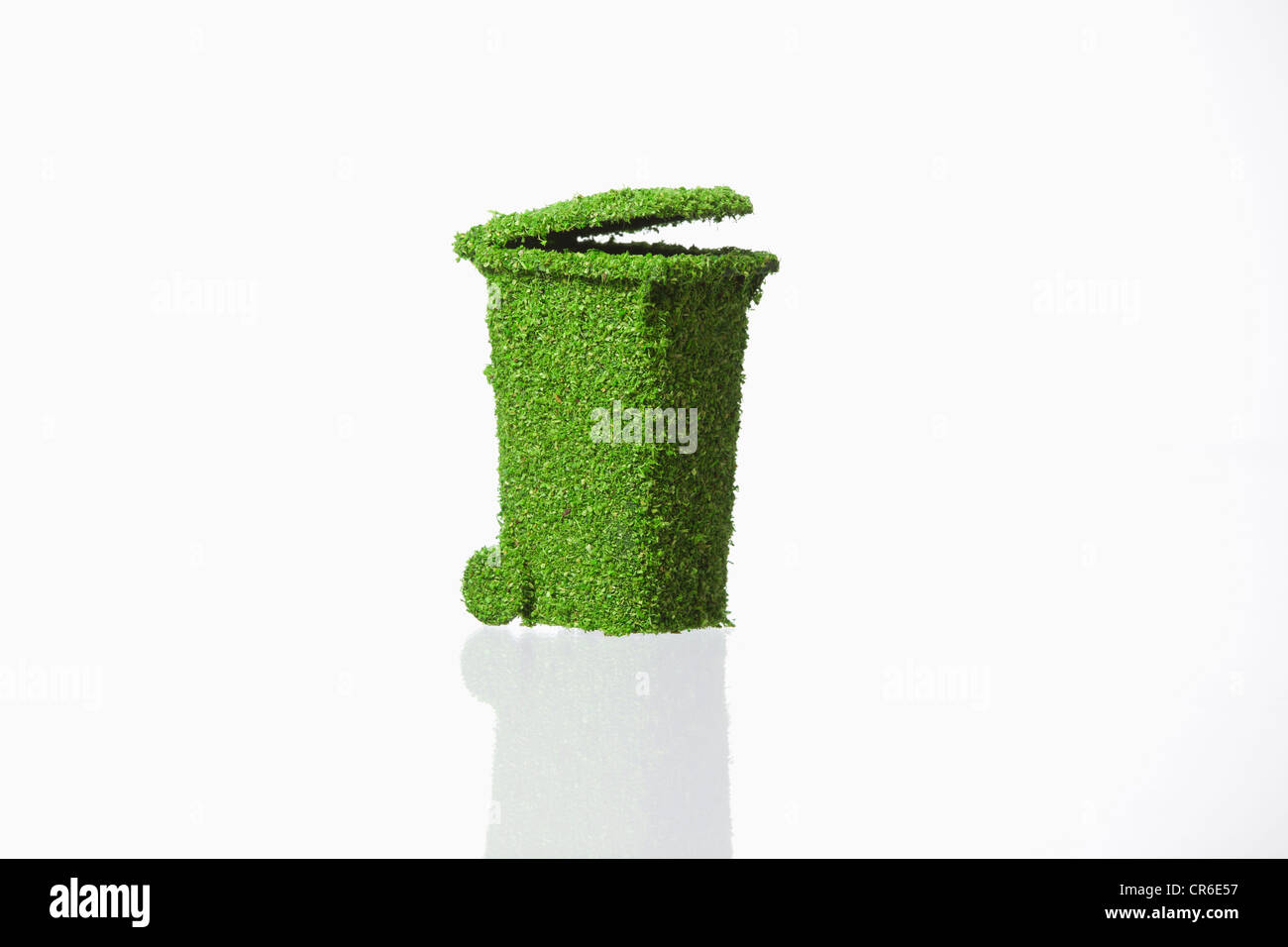 Rubbish bin covered with grass on white background Stock Photo