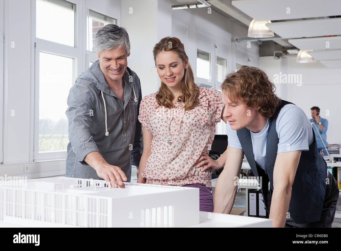 Germany, Bavaria, Munich, Man explaining architectural model to colleagues Stock Photo