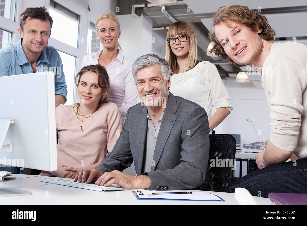 Germany, Bavaria, Munich, Men and women using computer in office ...
