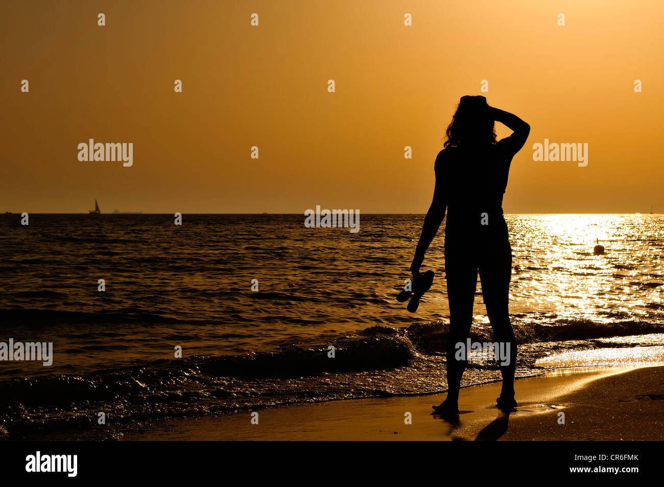 Woman standing on the beach looking out to the sea, evening mood, Lido di Ostia, Rome, Lazio region, Italy, Europe Stock Photo
