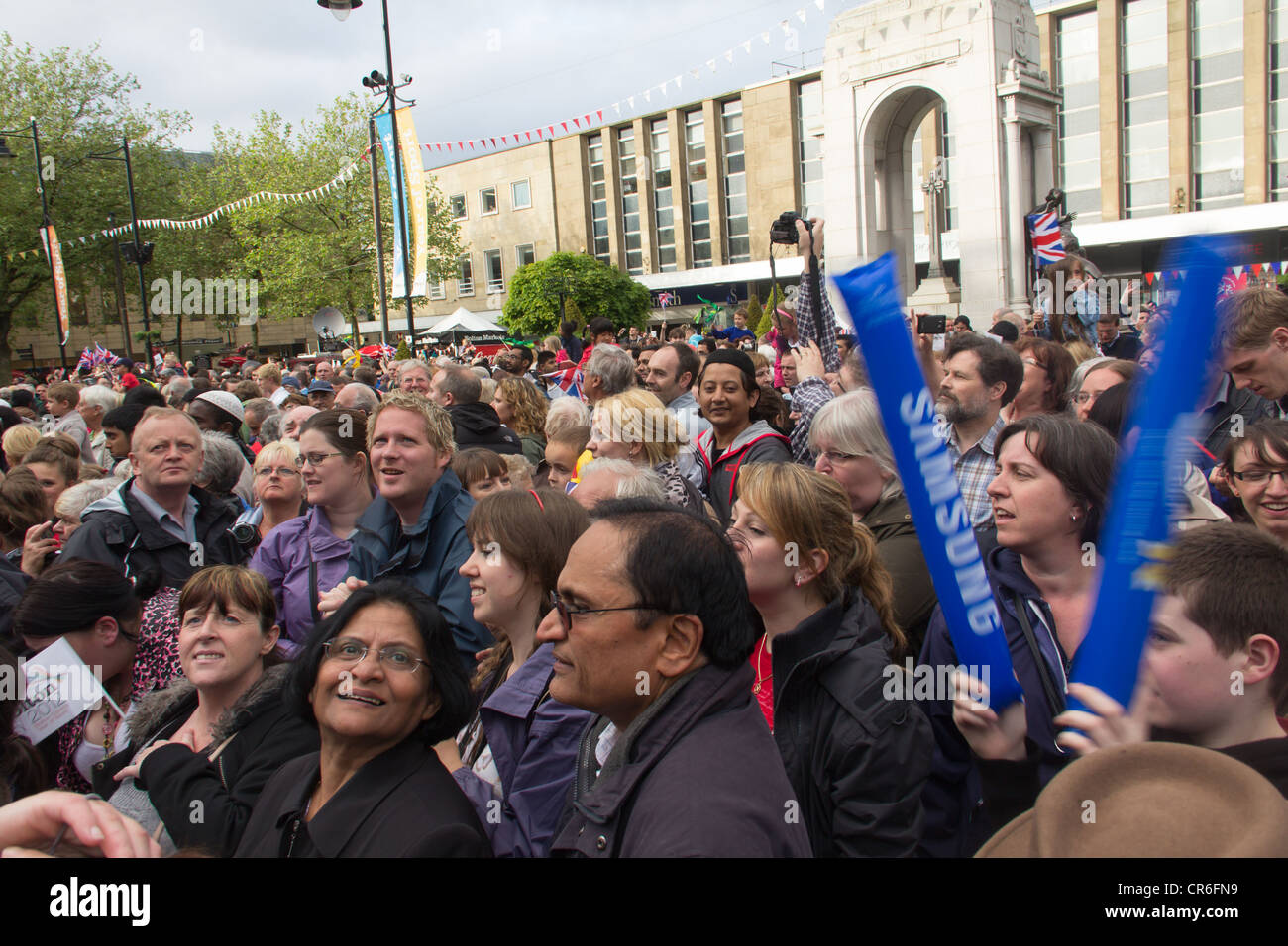 An excited crowd gathered in Victoria Square, Bolton to witness the arrival of the Olympic torch on its journey round the UK. Stock Photo