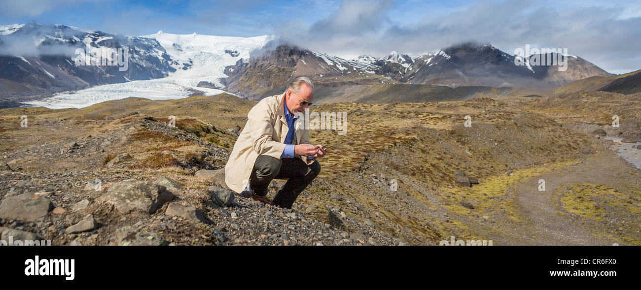 Scientist investigating the landscape. Kviarjokull Glacier in background, Vatnajokull Ice Cap, Iceland Stock Photo