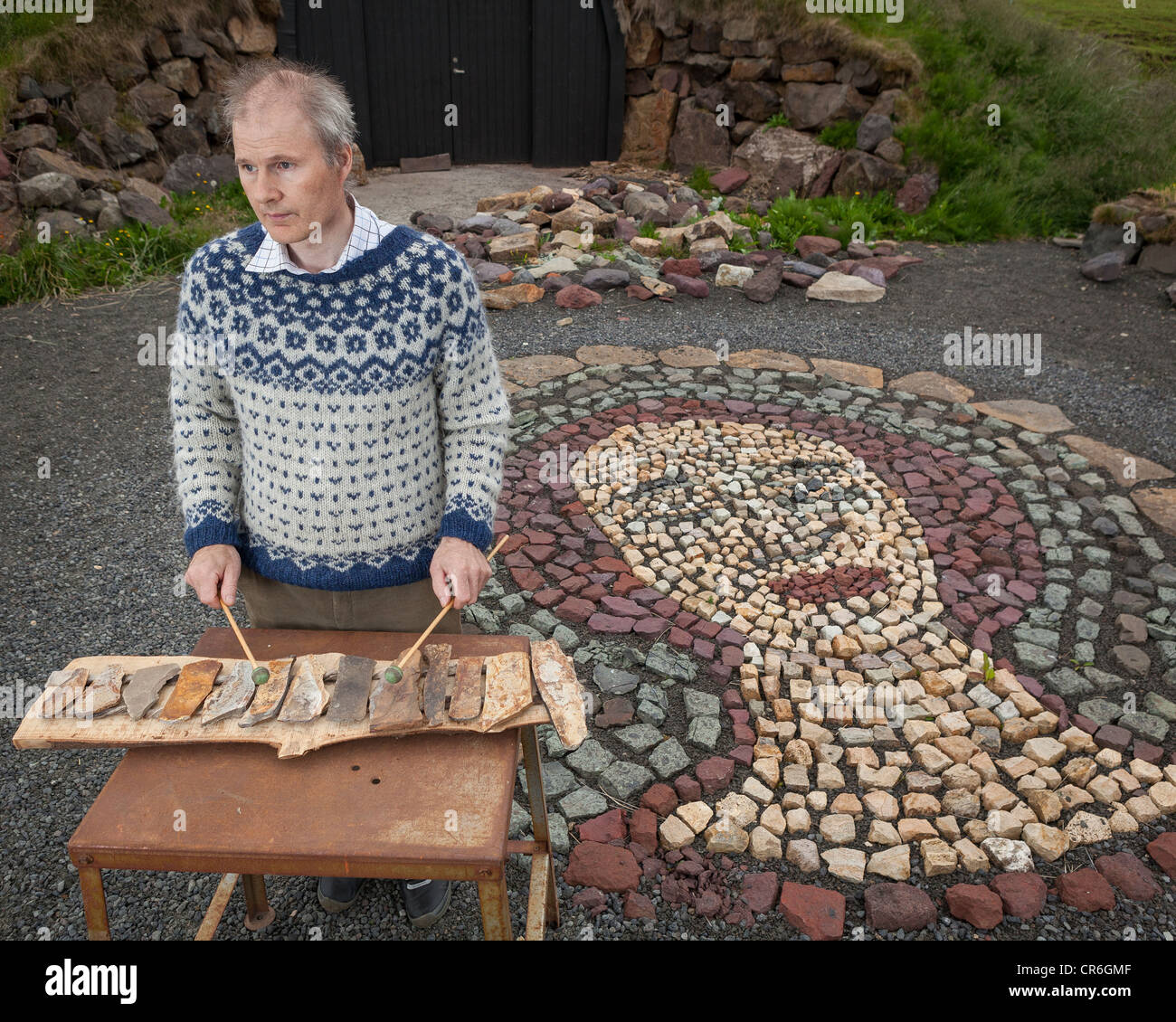 Stone Artist playing a xylophone,  Borgarfjordur , Iceland Stock Photo