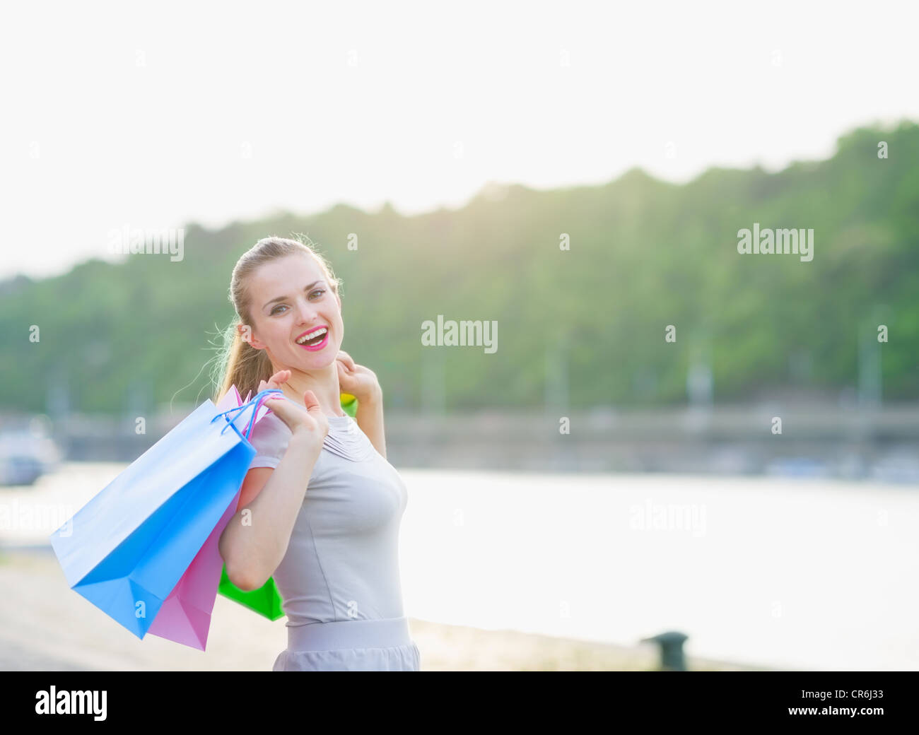 Happy woman with shopping bags walking quay Stock Photo