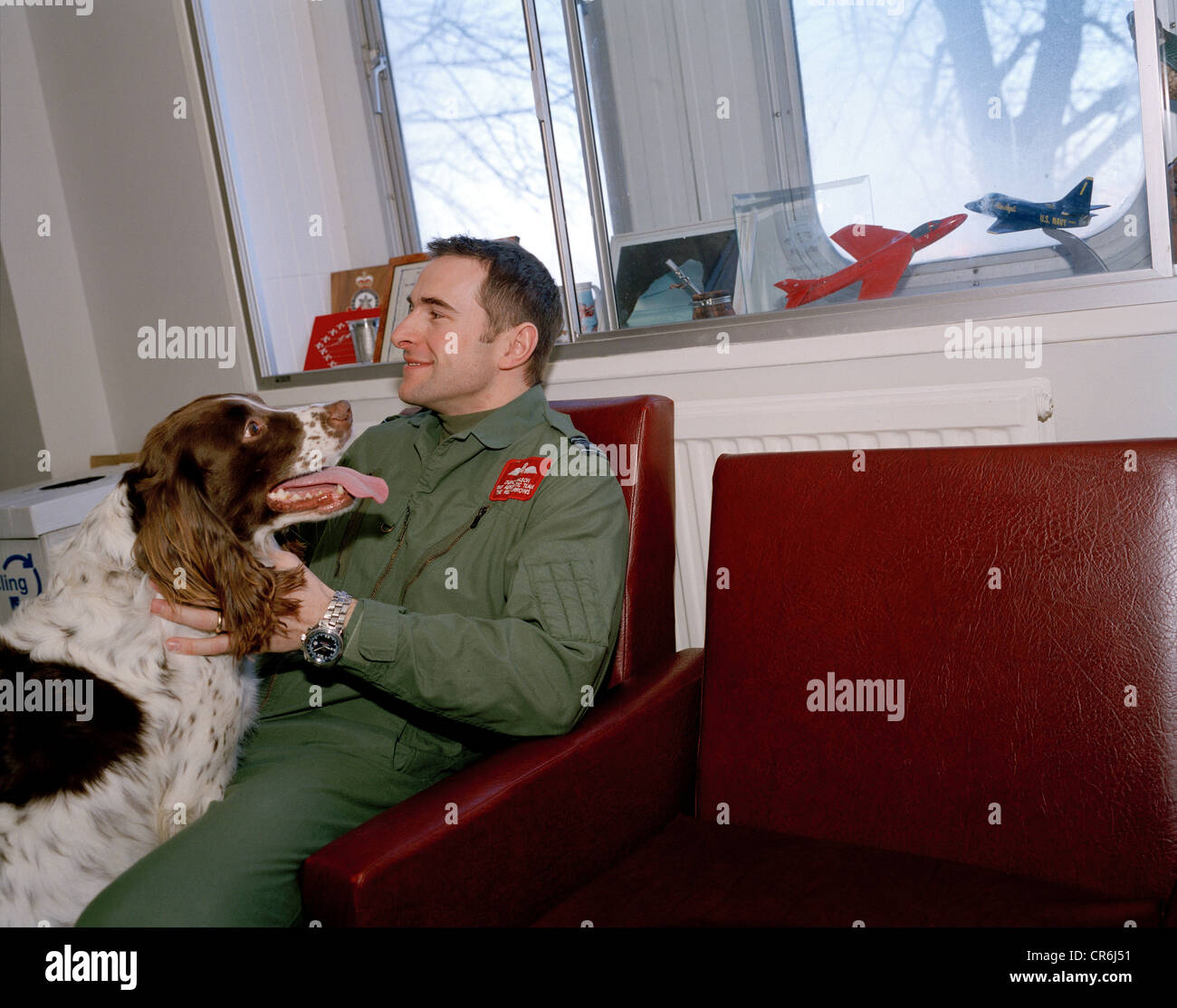 Pilot of the Red Arrows, Britain's RAF aerobatic team with his pet spaniel in the squadron crew room at RAF Scampton. Stock Photo
