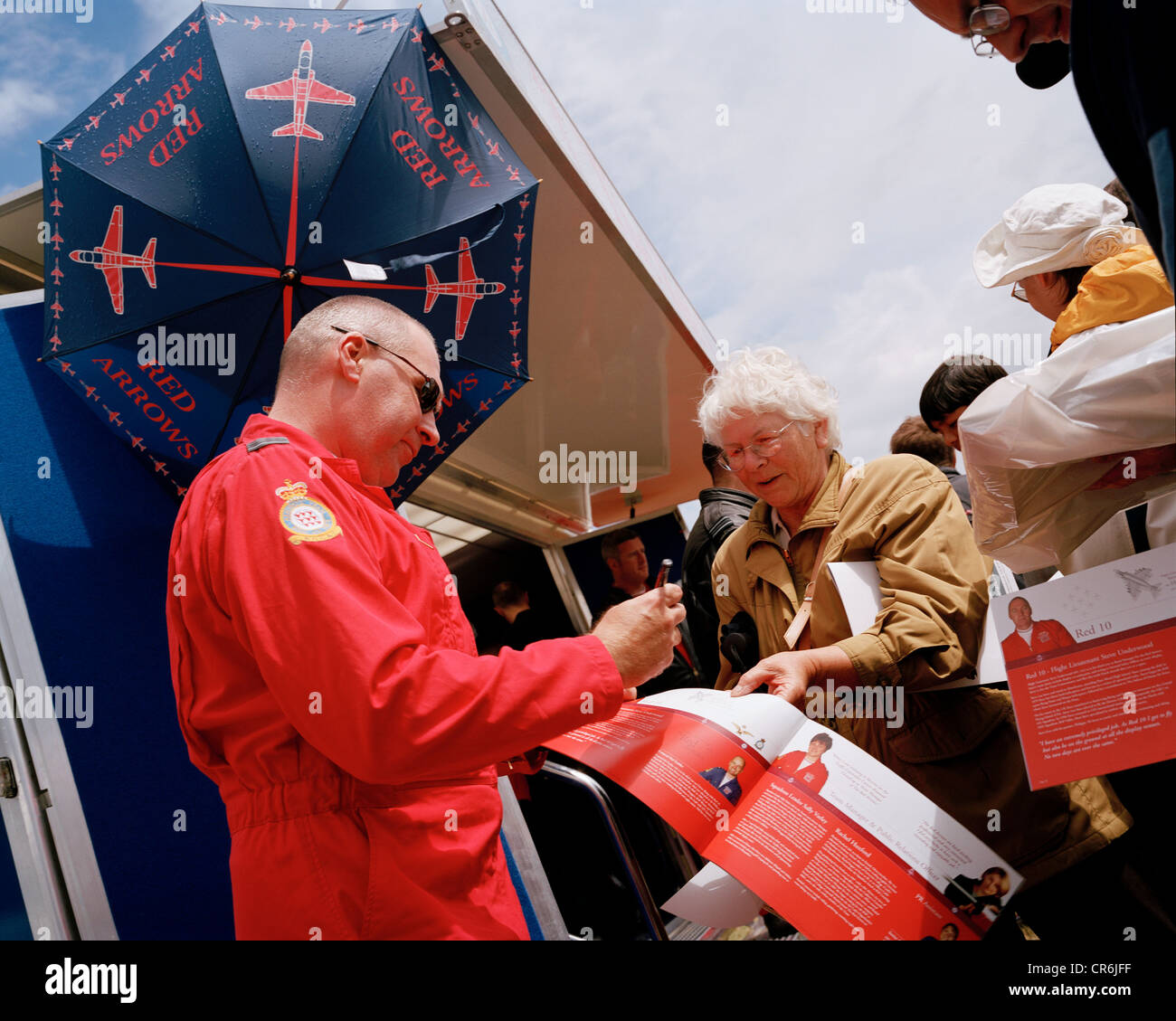 Pilot of the Red Arrows, Britain's RAF aerobatic team signs publicity brochures for the public during airshow. Stock Photo