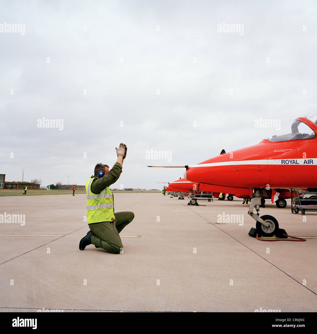 An engineer ground staff team member signals to a pilot of the Red Arrows, Britain's RAF aerobatic team. Stock Photo