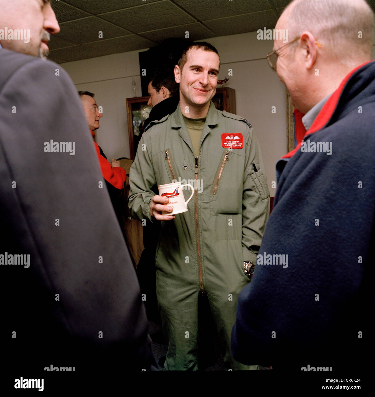 Pilot of the Red Arrows, Britain's RAF aerobatic team smiles politely during conversations with corporate guests. Stock Photo