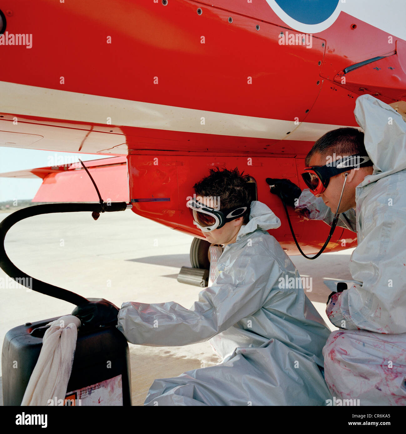 Dye team engineers refills the dye-derv mixture to a Hawk jet's the smoke pod of the Red Arrows, Britain's RAF aerobatic team. Stock Photo