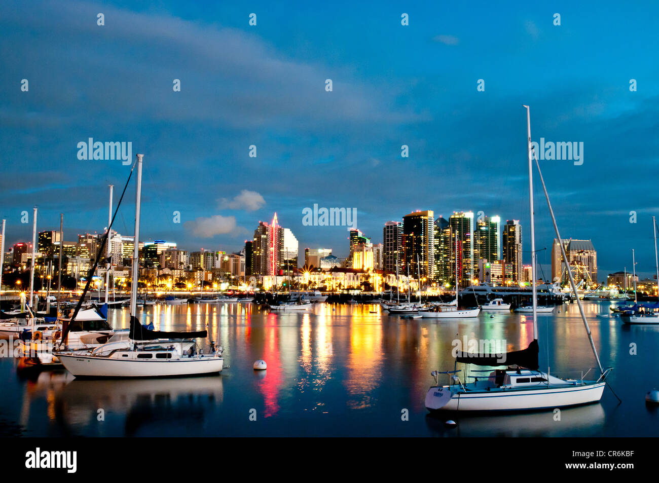 Sailboats in San Diego marina with city lights in background Stock Photo