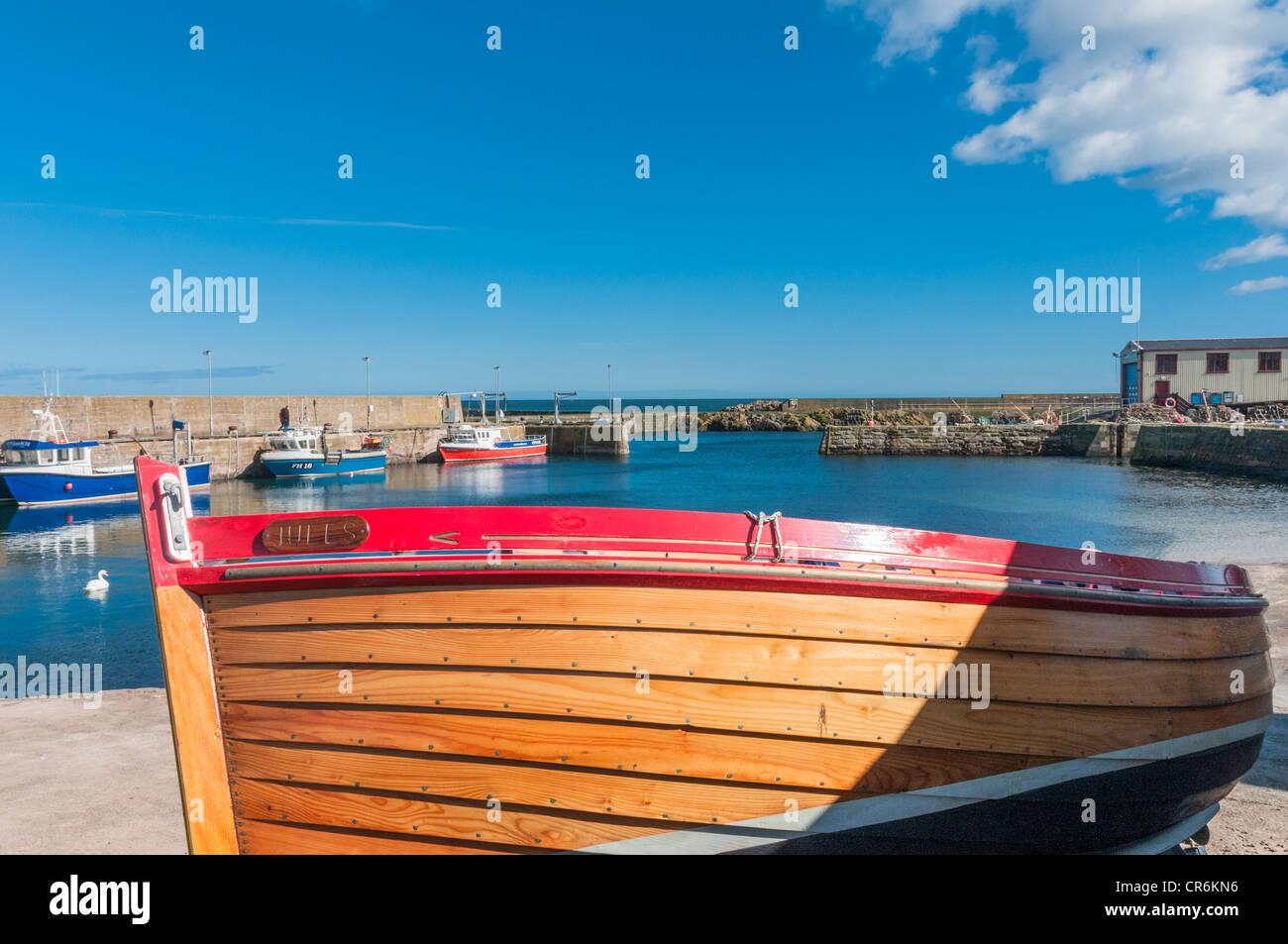Boat on Quayside and fishing boats in St Abbs harbour Scottish Borders