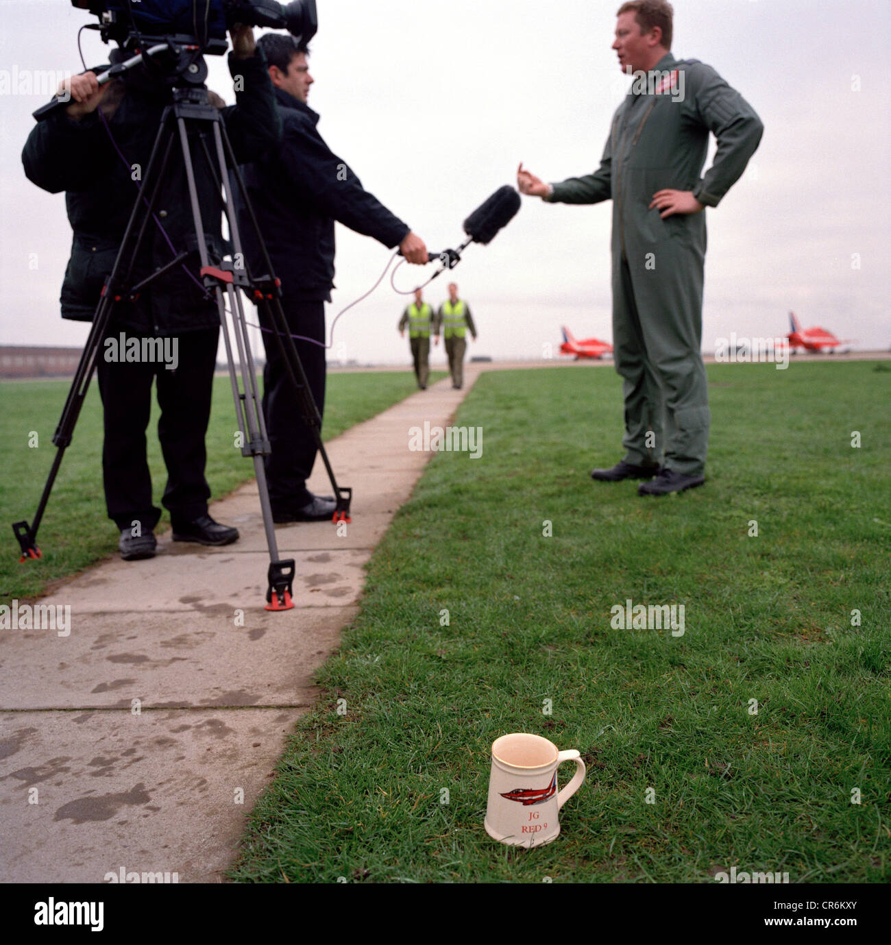 Pilot of the Red Arrows, Britain's RAF aerobatic team answers questions to local tv station, having left his cup of tea. Stock Photo