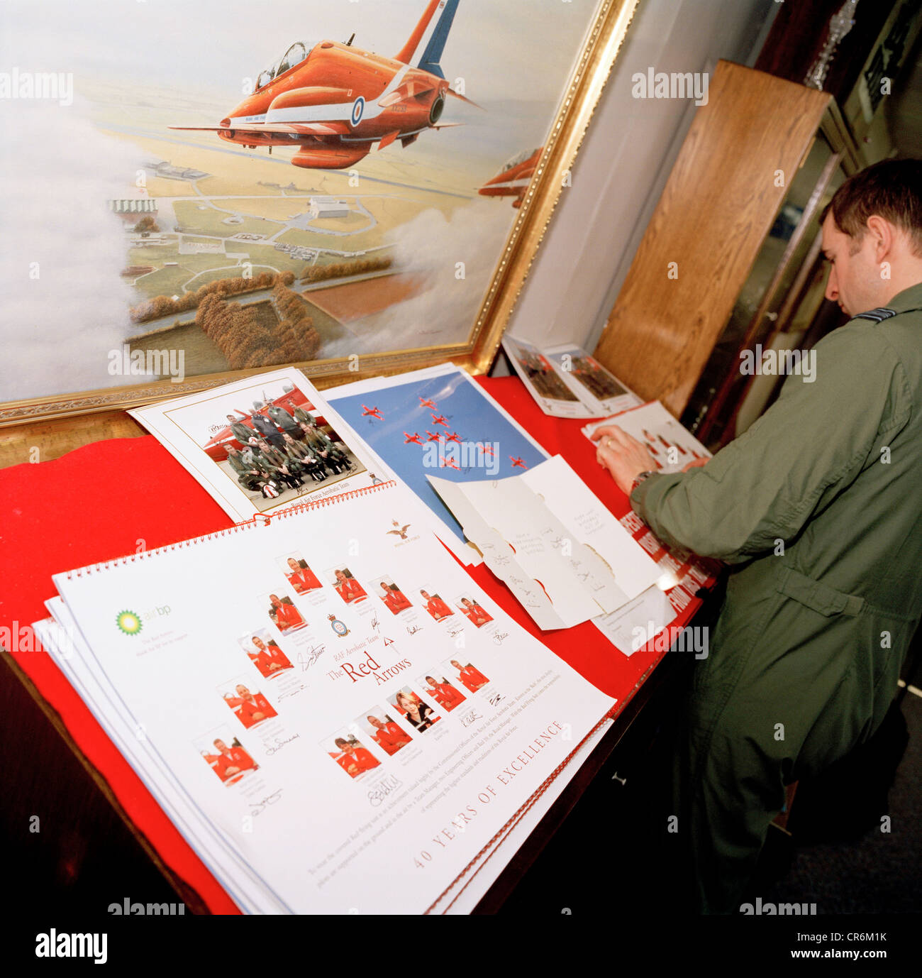 A pilot of the Red Arrows, Britain's RAF aerobatic team signs team publicity posters. Stock Photo