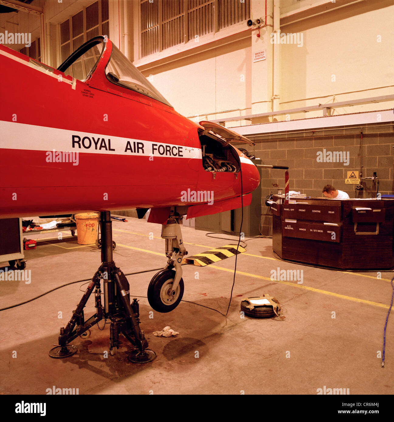 Scheduled maintenance on a Hawk  T.Mk.1 jet in the hangar of the Red Arrows, Britain's RAF aerobatic team. Stock Photo