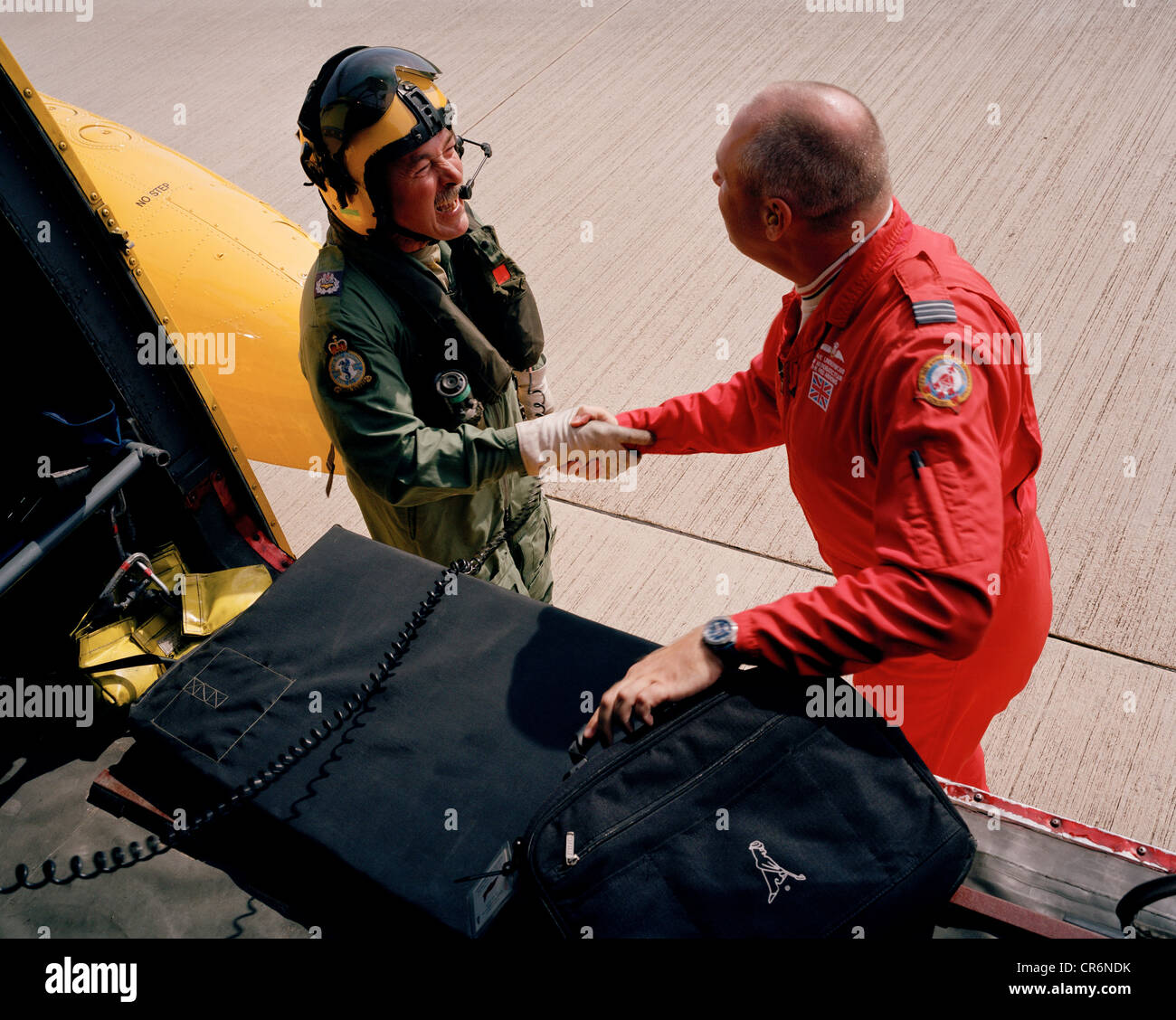 Member of the Red Arrows, Britain's RAF aerobatic team handshakes his helicopter ride's pilot after landing. Stock Photo