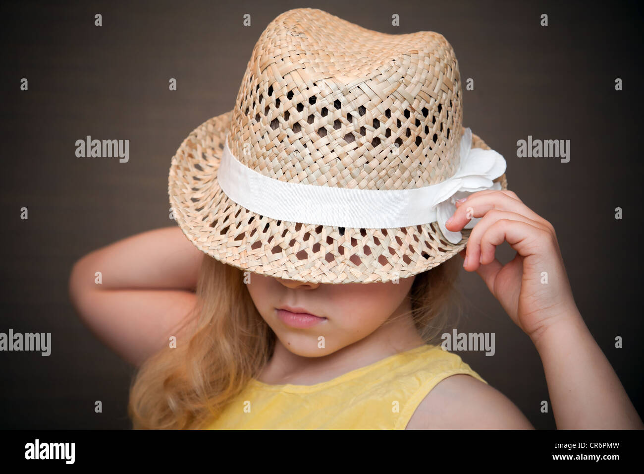 Closeup portrait of a little blond girl with straw hat Stock Photo