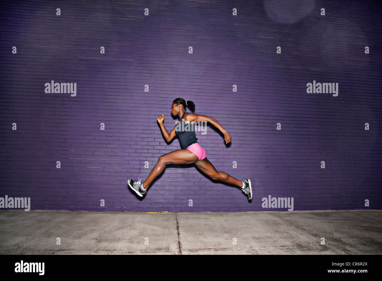 Female athlete running on sidewalk Stock Photo