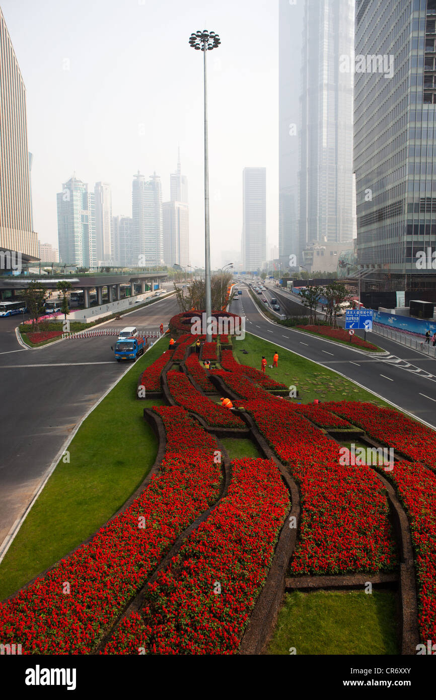 Bed of Red flowers leading up to a street light lamp in Shanghai China. Stock Photo