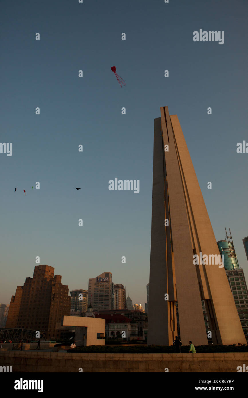 Sunrise on the bund with view of Monument of People's Heroes in China Shanghai and kites flying in sky Stock Photo