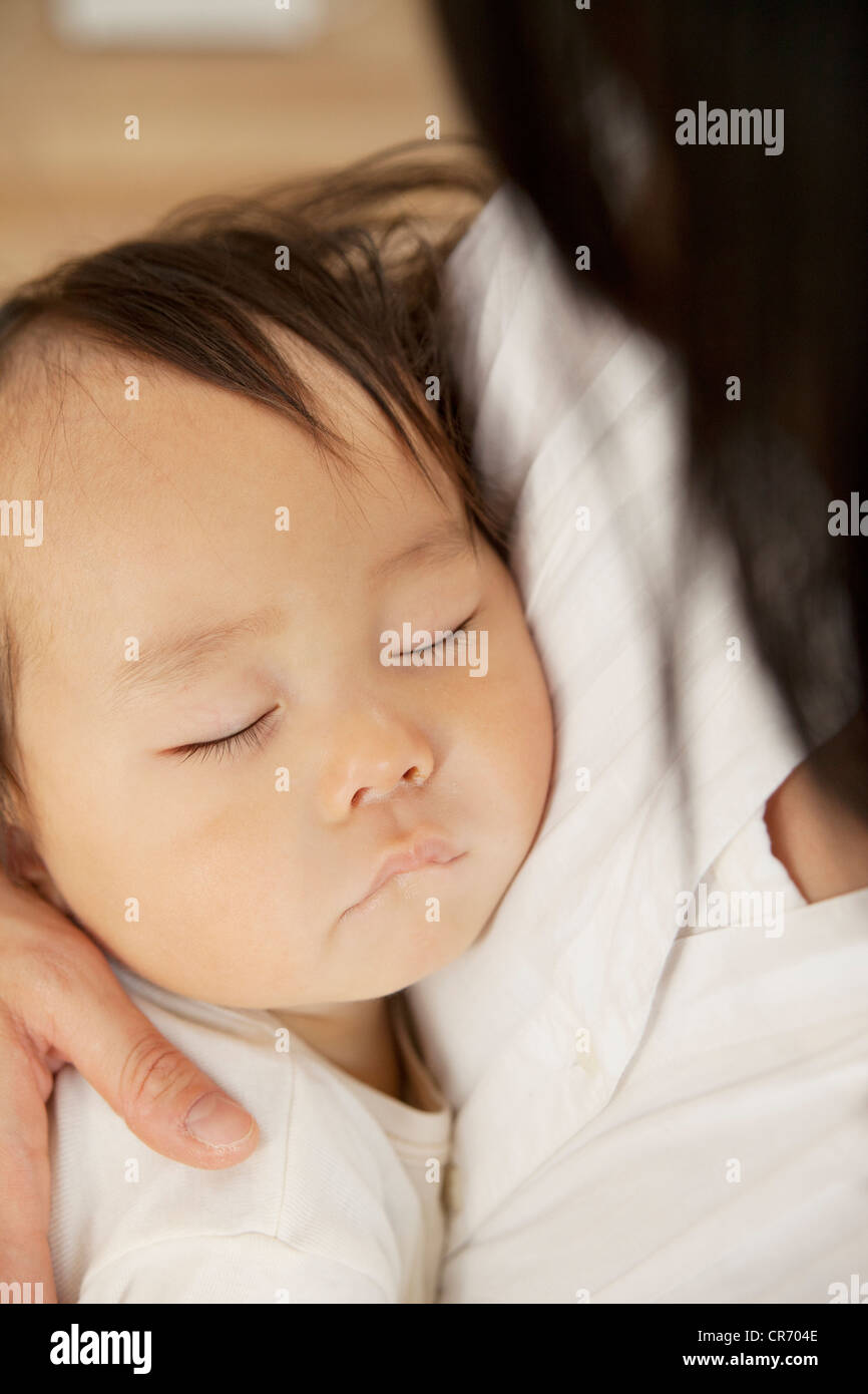 Baby sleeping in mother's arms Stock Photo Alamy