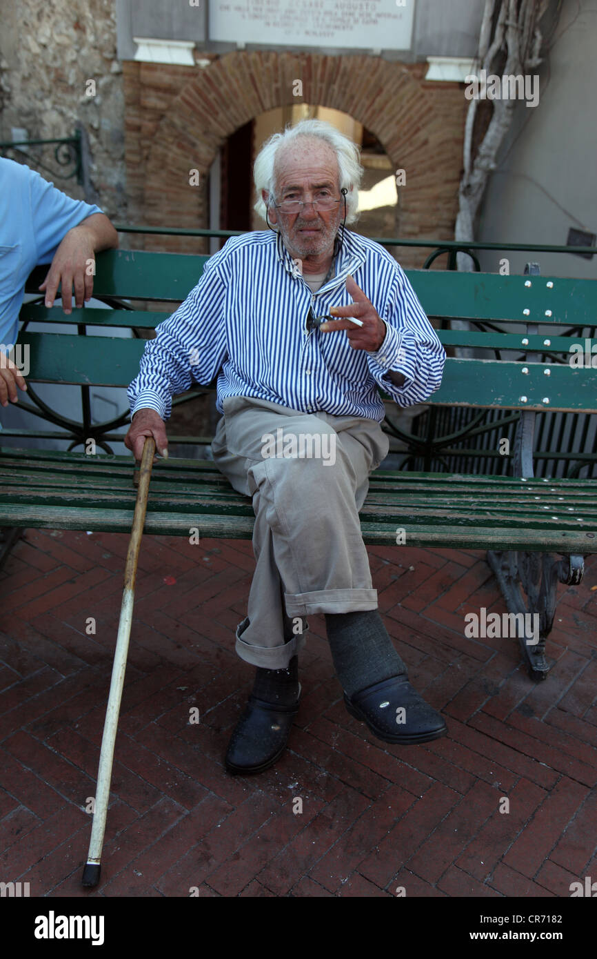 Capri resident with blind man's white stick, smoking a cigarette Stock Photo